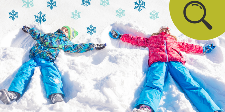 Zwei Kinder machen im weißen Schnee einen Schnee-Engel.