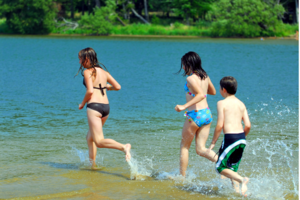 2 Mädchen und ein Junge laufen ins Wasser
