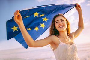 Mädchen hält EU Flagge in den Händen und lächelt