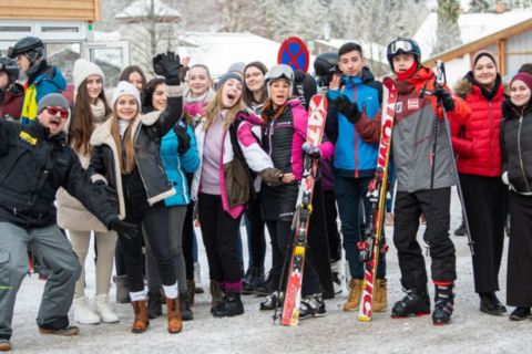 Mehrere Schüler in Skianzügen stehen vor der Talstation
