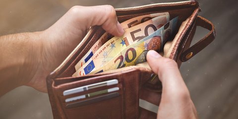 Hände öffnen eine Lederbrieftasche mit Euro-Banknoten darin