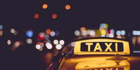 Nahaufnahme eines Taxischildes auf einem Taxi während Nacht