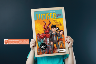 Buch hält einen Rahmen mit dem Buchcover des Buchtipps "Luzifer junior - Zu gut für die Hölle"
