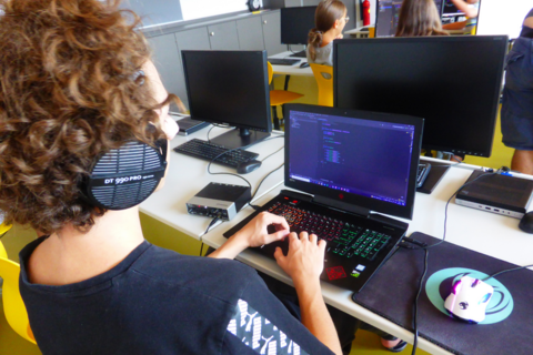 Jugendlicher mit Kopfhörer schreibt Code, DigiCamp 2021