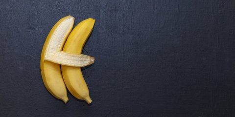 zwei Bananen an einer Tafel, eine Banane umarmt die andere