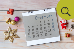 Kalender mit "Dezember"-Seite liegt auf einem weihnachtlichen Untergrund